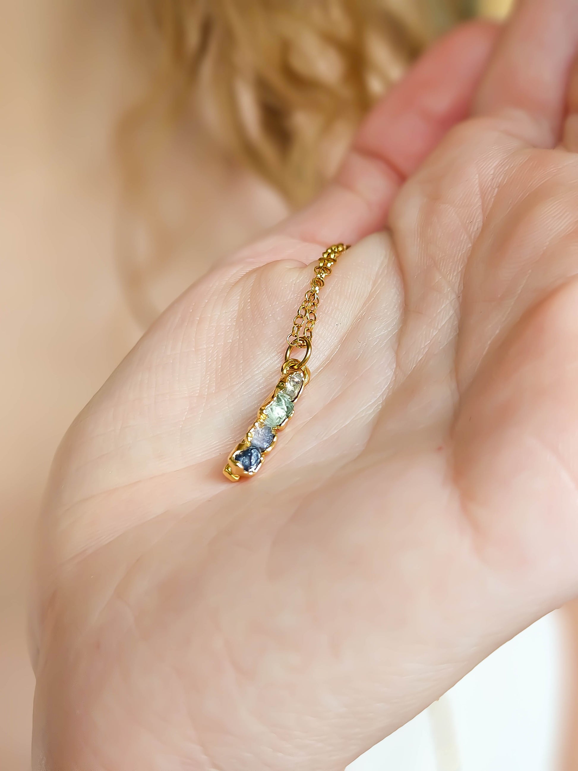 Détail des pierres de naissance naturelles montées sur un pendentif fait main